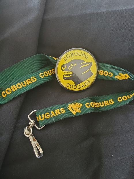 Cobourg Cougars metal button with green lanyard